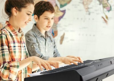 jongen en meisje hebben pianoles en keyboardles op een yamaha piano